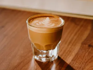 Foto de espresso en vaso de cristal con latte art 