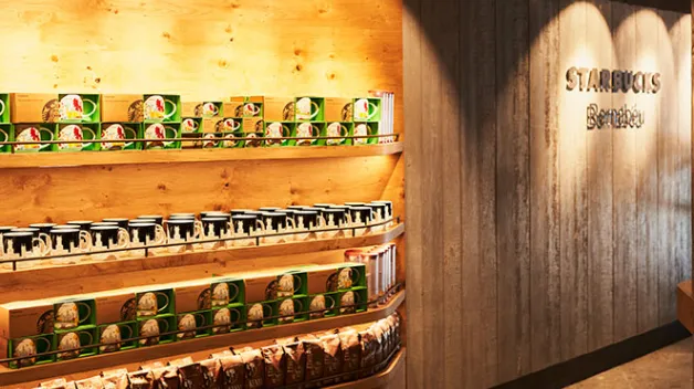 Imagen de la esquina donde está el merchandising local (Madrid y España). Se ve el logo de Starbucks Bernabeu sobre pared de madera