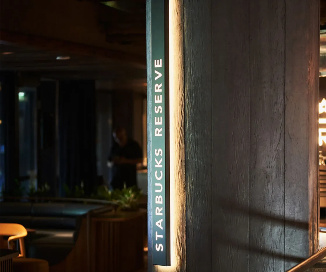 Imagen de logo de Starbucks Reserve iluminado sobre columna de tienda