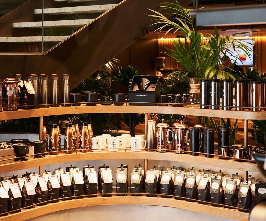 Imagen de paquetes de café, termos, botellas y tazas, en la zona de merchandising