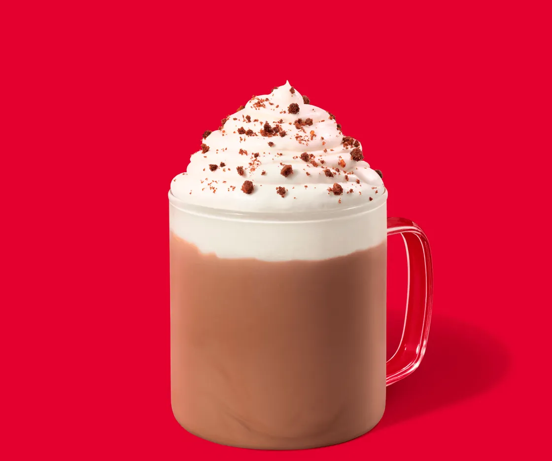 Caramel Cookie Hot Chocolate en un taza de vidrio con fondo rojo