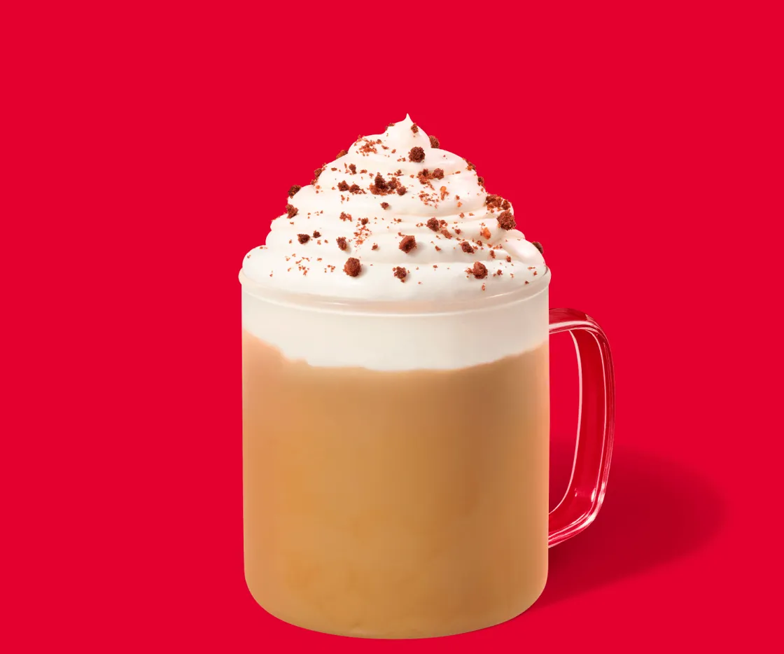 Caramel Cookie Latte caliente en un taza de vidrio con fondo rojo