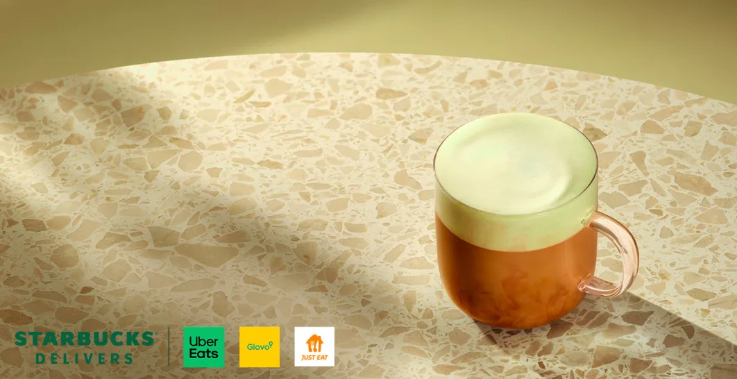 Una taza de vidrio con café caliente, sobre una mesa